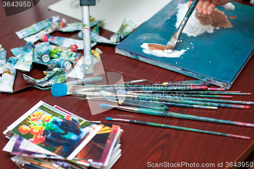 Image of Artist\'s hands close-up on the background of palette 