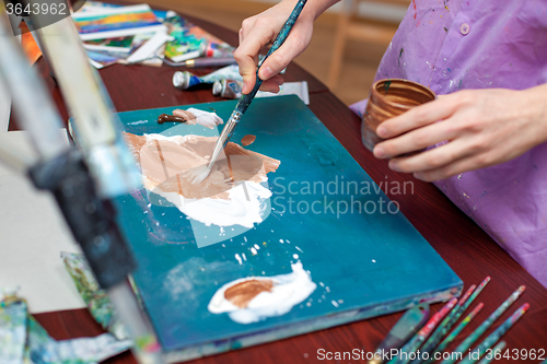 Image of Artist\'s hands close-up on the background of palette 