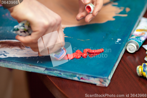 Image of Artist\'s hands close-up on the background of palette 