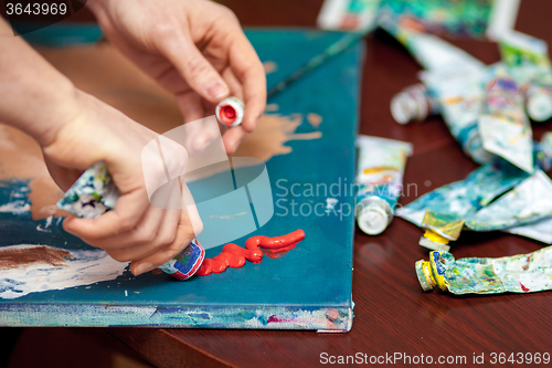 Image of Artist\'s hands close-up on the background of palette 