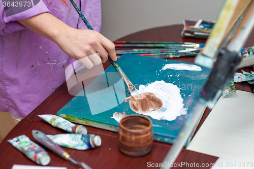 Image of Artist\'s hand close-up on the background of palette 