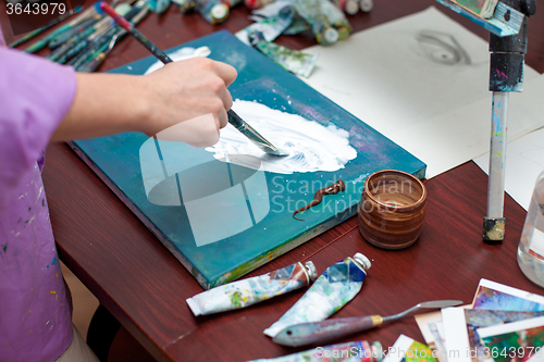 Image of Artist\'s hand close-up on the background of palette 