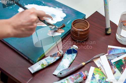 Image of Artist\'s hand close-up on the background of palette 