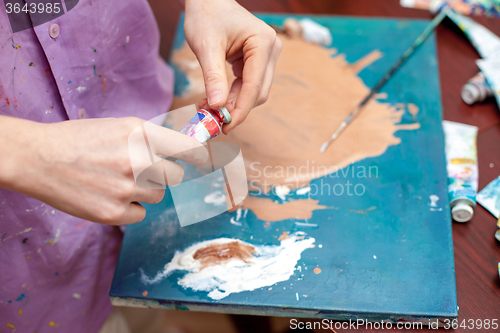 Image of Artist\'s hands close-up on the background of palette 