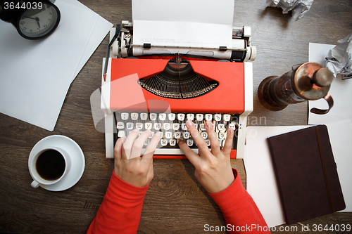 Image of Vintage red typewriter with blank paper