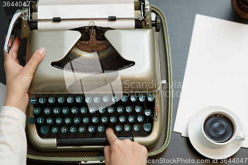 Image of closeup of coffee and hands writing