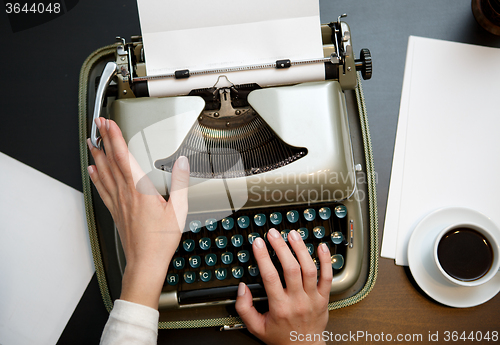 Image of closeup of coffee and hands writing