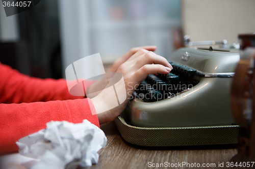 Image of Hands of a man typing on typewriter