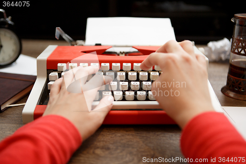 Image of Vintage red typewriter with blank paper