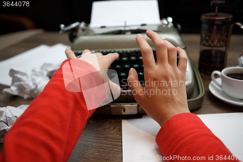 Image of woman typing on old typewriter