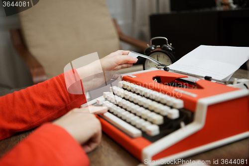 Image of Vintage red typewriter with blank paper