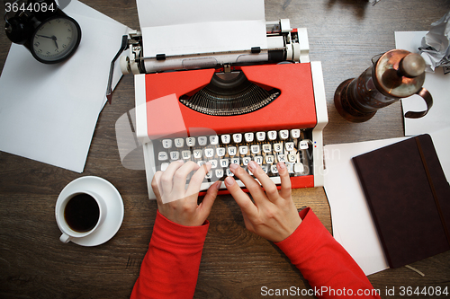 Image of Vintage red typewriter with blank paper