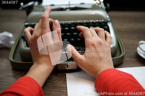 Image of woman typing on old typewriter