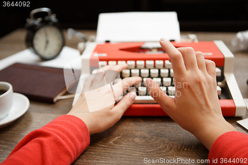 Image of Vintage red typewriter with blank paper