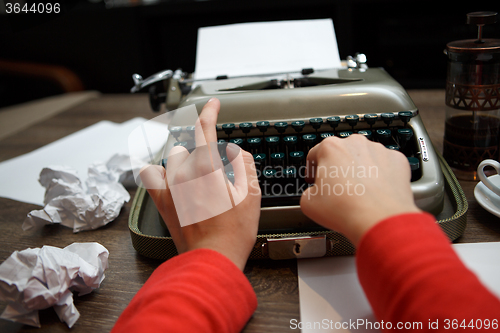 Image of woman typing on old typewriter