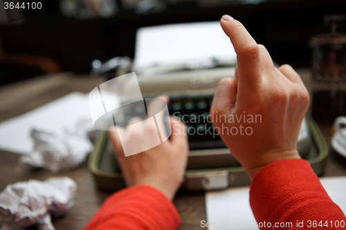 Image of woman typing on old typewriter