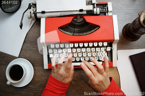 Image of Vintage red typewriter with blank paper