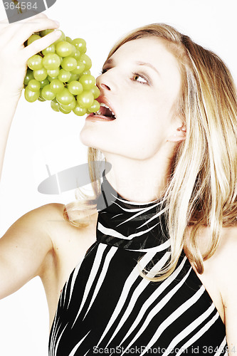 Image of Young woman eating grapes