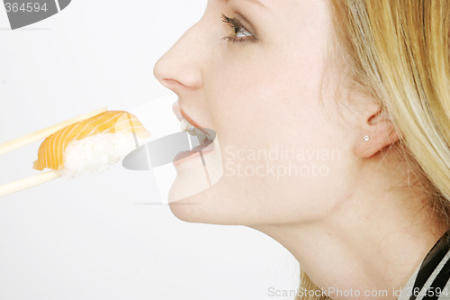 Image of Young woman eating sushi