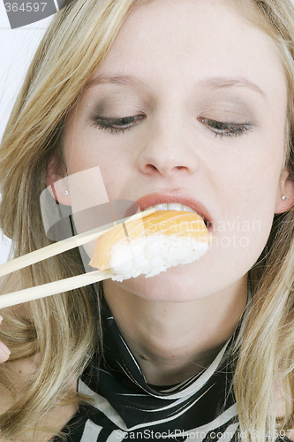 Image of Young woman eating sushi