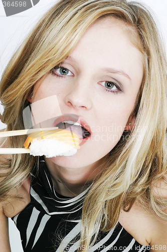 Image of Young woman eating sushi