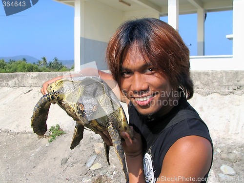 Image of Boy holding sea turtle
