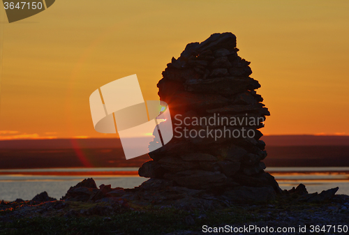 Image of Built from stone Cairn at sunset, at midnight, the polar day