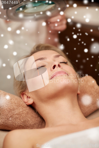 Image of close up of young woman and beautician in spa