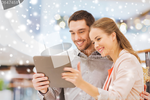 Image of happy couple with tablet pc taking selfie in mall