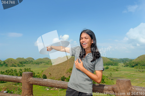 Image of Asian young tourist showing landmark