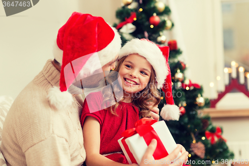 Image of smiling father and daughter holding gift box