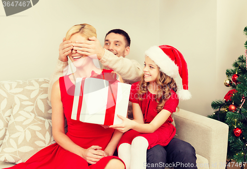 Image of father and daughter surprise mother with gift box