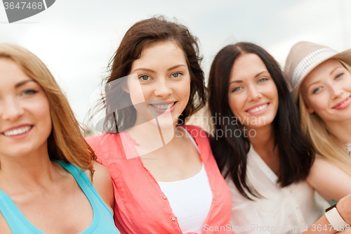 Image of group of smiling girls chilling on the beach