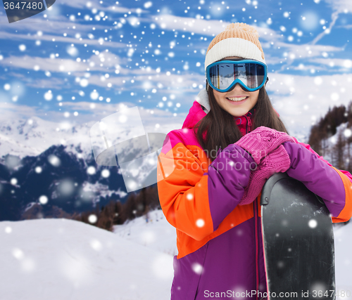 Image of happy young woman with snowboard over mountains