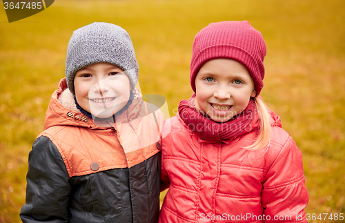 Image of happy little girl and boy in autumn park