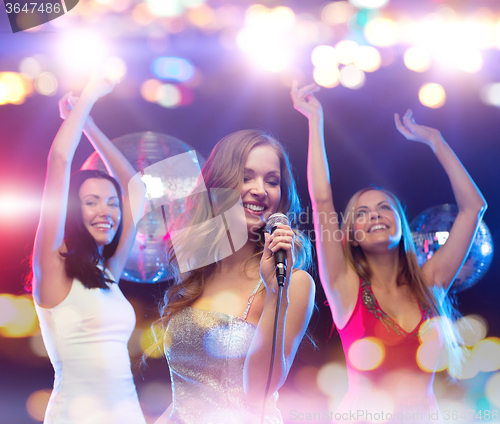 Image of happy women singing karaoke and dancing