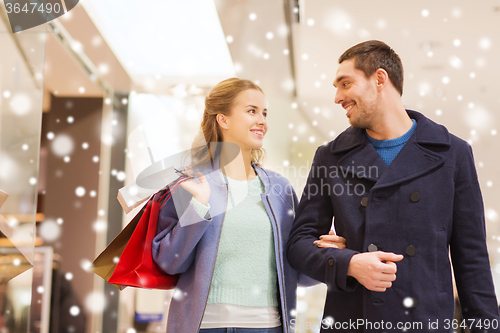 Image of happy young couple with shopping bags in mall