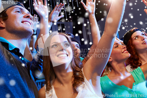 Image of smiling friends at concert in club