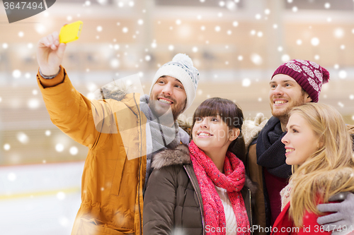 Image of happy friends taking selfie on skating rink