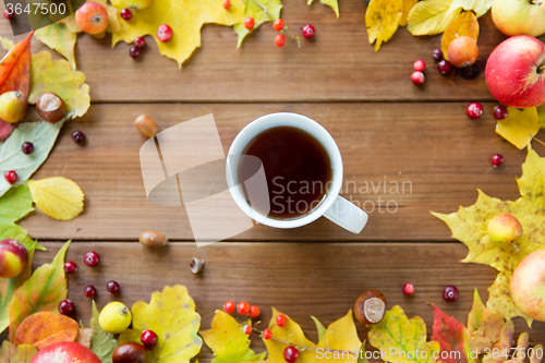 Image of close up of tea cup on table with autumn leaves