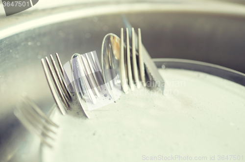 Image of close up of dirty dishes washing in kitchen sink