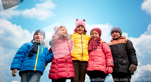 Image of happy children hugging over blue sky background