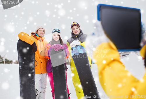 Image of happy friends with snowboards and tablet pc