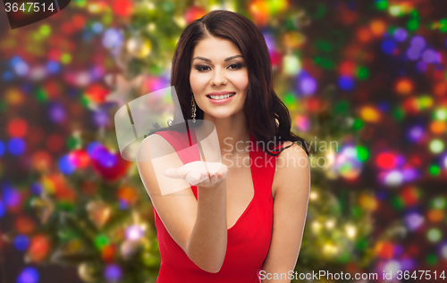 Image of beautiful woman in red dress showing empty hand