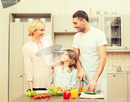 Image of happy family making dinner in kitchen