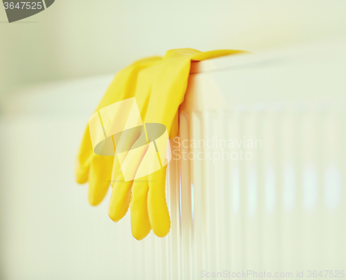 Image of close up of rubber gloves hanging on heater