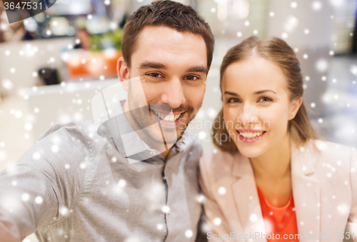 Image of happy couple taking selfie in mall or office