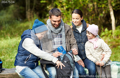 Image of happy family with backpack and thermos at camp