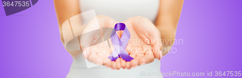 Image of close up of hands holding purple awareness ribbon