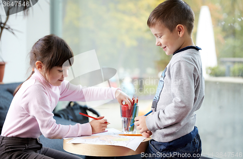 Image of happy little girl and boy drawing at home